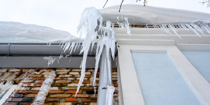 Close-up of icicles on the roof. look after your home in the cold